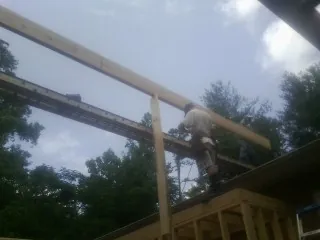 Carpenter setting a ridge beam over a new addition frame — Ice Dam Removal by Roofing Brothers in Hiawassee