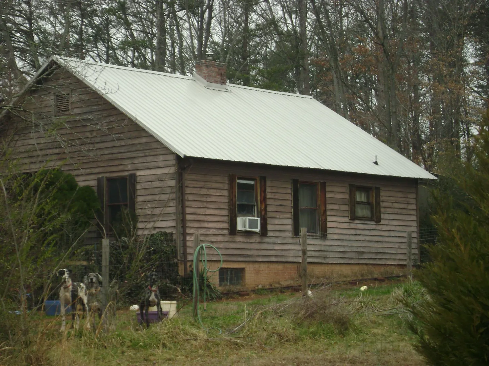 White metal roof on an old wood sided farmhouse, from a Metal Roof Installation job in Hiawassee